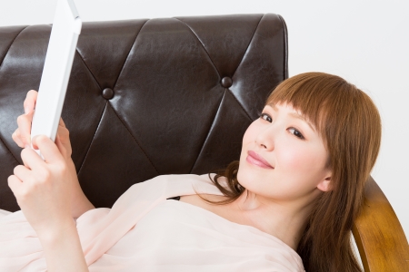 Beautiful young asian woman using tablet computerの写真素材