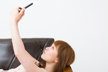 The Young woman who uses the smartphone in a roomの写真素材