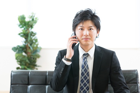 Young businessman who talks on the telephoneの写真素材