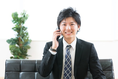 Young businessman who talks on the telephoneの写真素材
