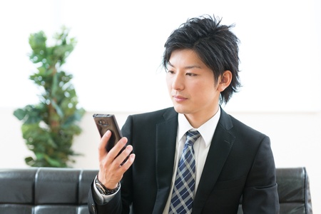Young businessman to see a smart phoneの写真素材