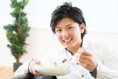 young man who eats saladの写真素材