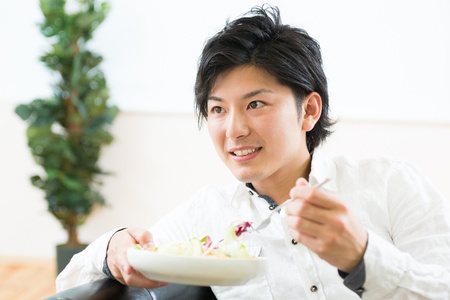 young man who eats saladの写真素材
