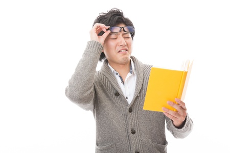 young attractive asian man who reads a bookの写真素材