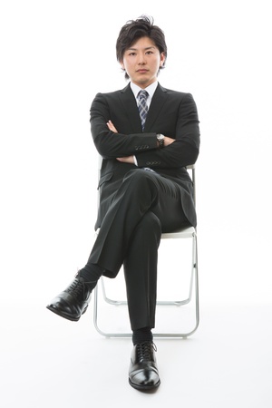 young businessman who sits down on a chairの写真素材