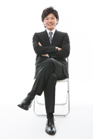 young businessman who sits down on a chairの写真素材