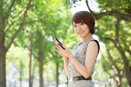 Beautiful young asian woman who see a smart phoneの写真素材