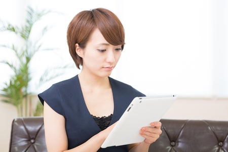 Beautiful young asian woman using tablet computerの写真素材