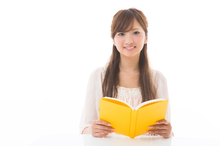 young attractive asian woman who reads a bookの写真素材