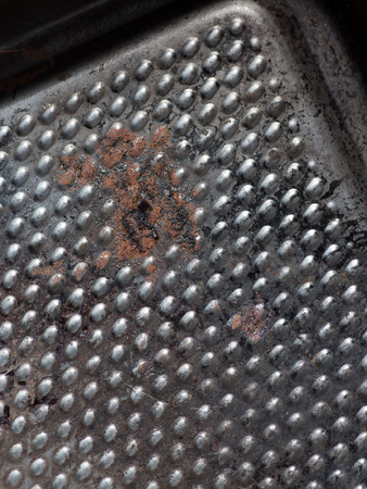 Details of a square used iron pan  with some burnt deposits and rustの写真素材
