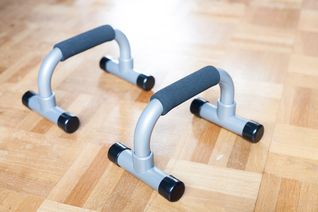A pair of plastic pushup bar on the wooden floorの写真素材