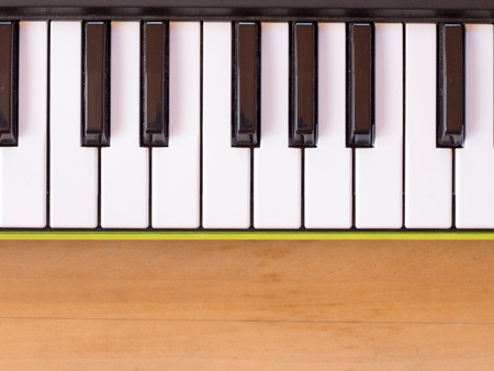 Keyboard of mini digital piano on wooden tableの写真素材