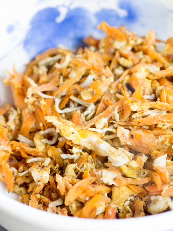 Japanese cuisine, fried shredded carrots, boiled young sardines and eggs in the bowlの写真素材
