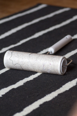 Dirty lint roller on a black and white carpet
