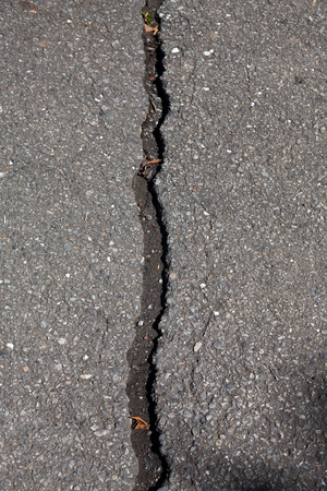 Straight crack in asphalt pavement roadの写真素材