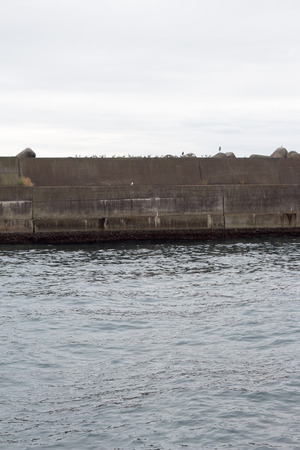 Breakwater, seawall on cold cloudy day in Japanの写真素材