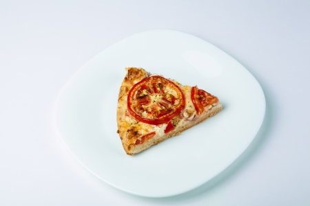a slice of pizza on a white plate close-upの写真素材