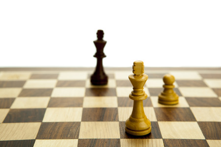 chess pieces on the board on white backgroundの写真素材