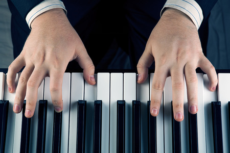 Piano keys and human hands close-upの写真素材