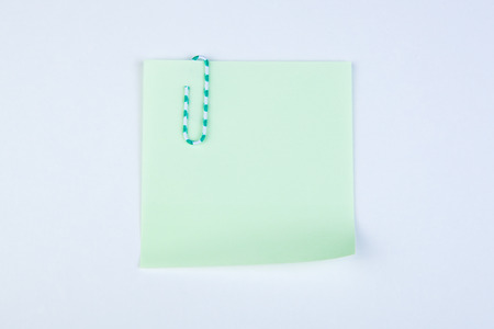sheet of pad green paper witn paper clip close-up