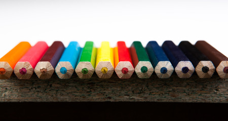row of colored pencils close-up on whiteの写真素材