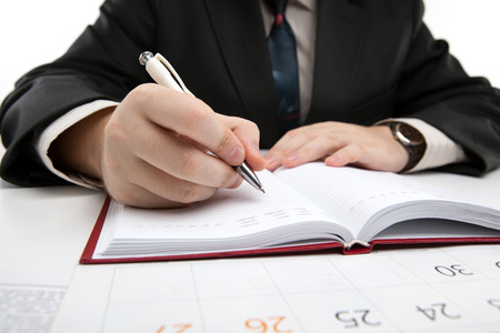 diary and human hand holding a pen close-upの写真素材