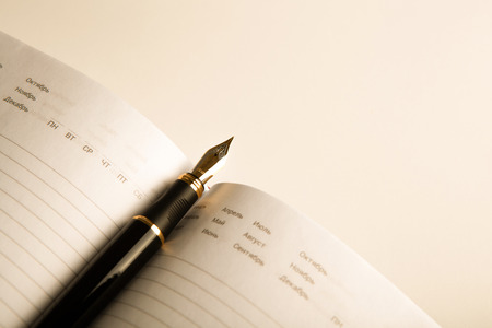 diary with fountain pen on white close-up
