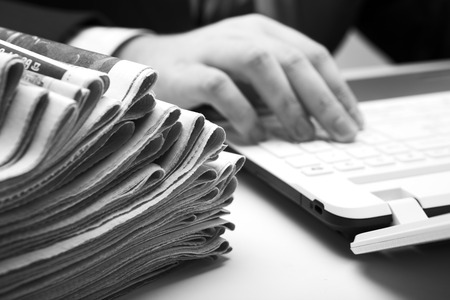 stack of newspapers in office close-up on white