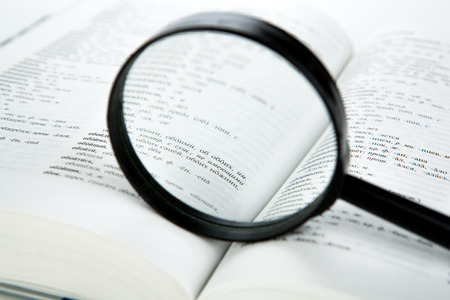 open book with loupe closeup on a white backgroundのeditorial素材