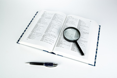 open book with loupe closeup on a white backgroundのeditorial素材