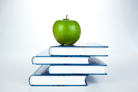 stack of books with green apple on a whiteの写真素材