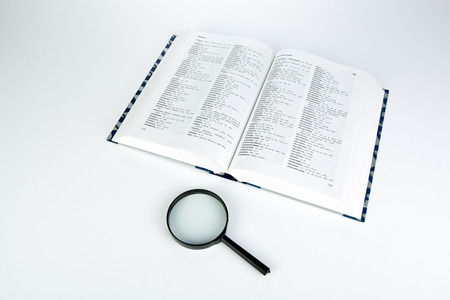 open book with loupe closeup on a white background