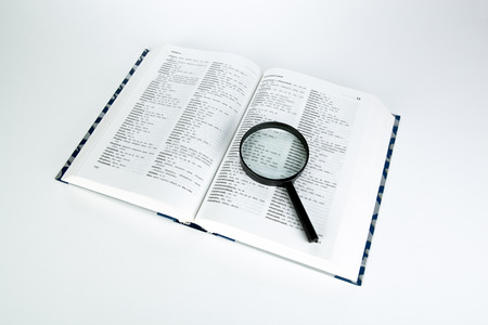 open book with loupe closeup on a white background