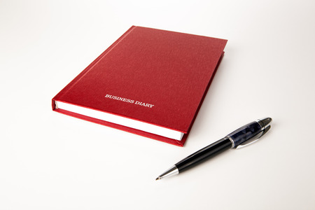 open diary with large pen on whiteの写真素材