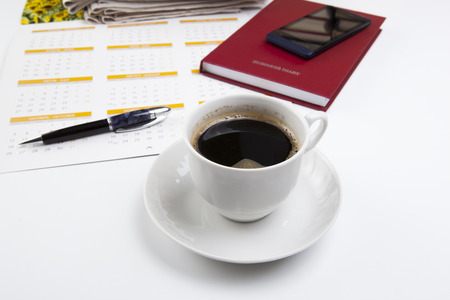 business still life consisting of sheet of a calendar, telephone, diary, pen, stack of newspapersの写真素材