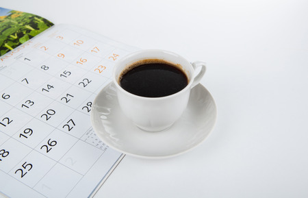 cup of coffee with wall calendar on a white backgroundの写真素材