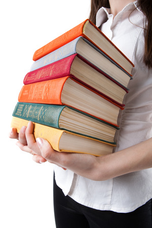 young girl holding a stack of books isolated on a white backgroundの写真素材