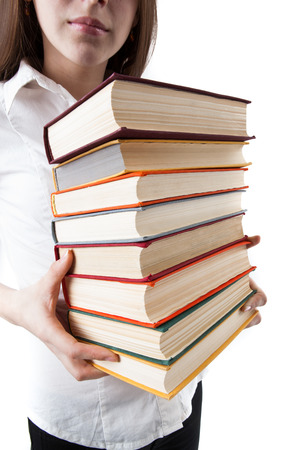 young girl holding a stack of books isolated on a white backgroundの写真素材