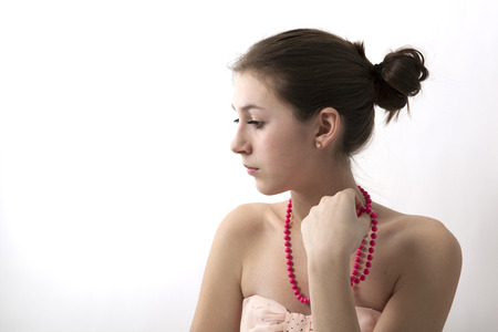 portrait of a girl with pink beads on greyの写真素材