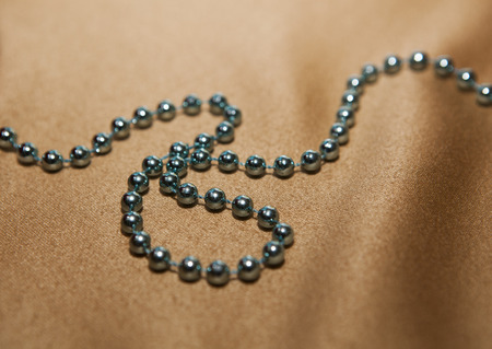 abstract beads lie on a beige fabric closeupの写真素材