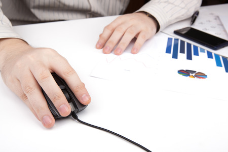 hand on a computer mouse at work close-upの写真素材
