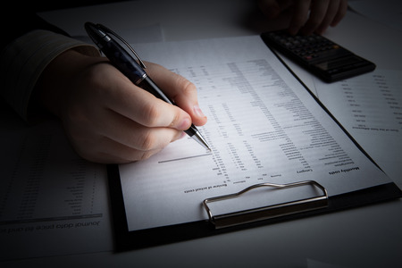 man is looking for information in the in the budget figures close-upの写真素材