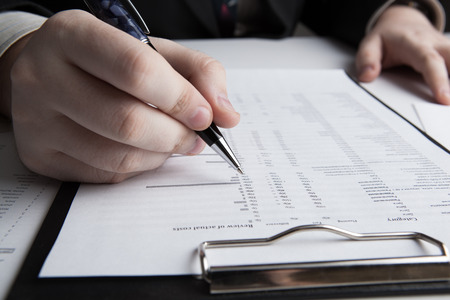 man is looking for information in the in the budget figures close-upの写真素材