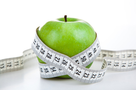 green apple with a ruler on a white backgroundの写真素材
