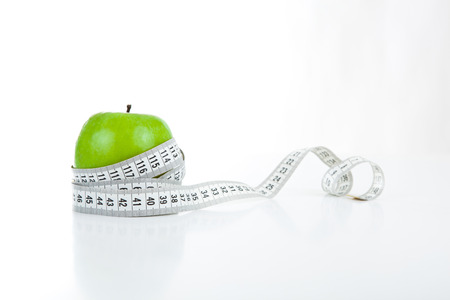 green apple with a ruler on a white backgroundの写真素材