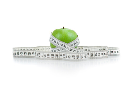green apple with a ruler on a white backgroundの写真素材