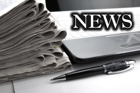 stack of newspapers and keyboard close-up on whiteの写真素材