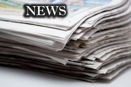 stack of newspapers on a white background closeupの写真素材