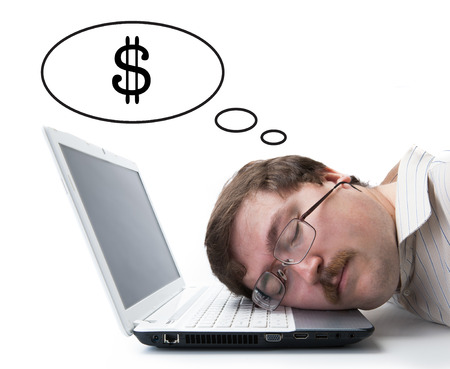 employee at the computer dreaming currency on a white の写真素材