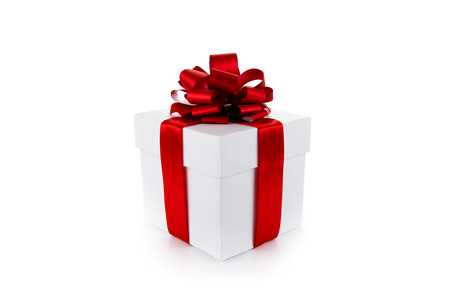 White gift box with red ribbon and bow isolatedの写真素材